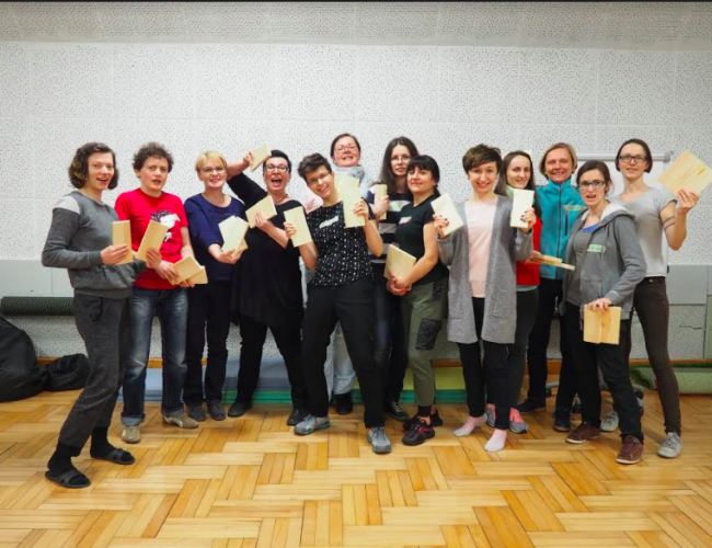 Self-defence trainer Kinga Karp stands with a group of women smiling and holding up their Wen-Do certificates to celebrate their accreditation as trainers.